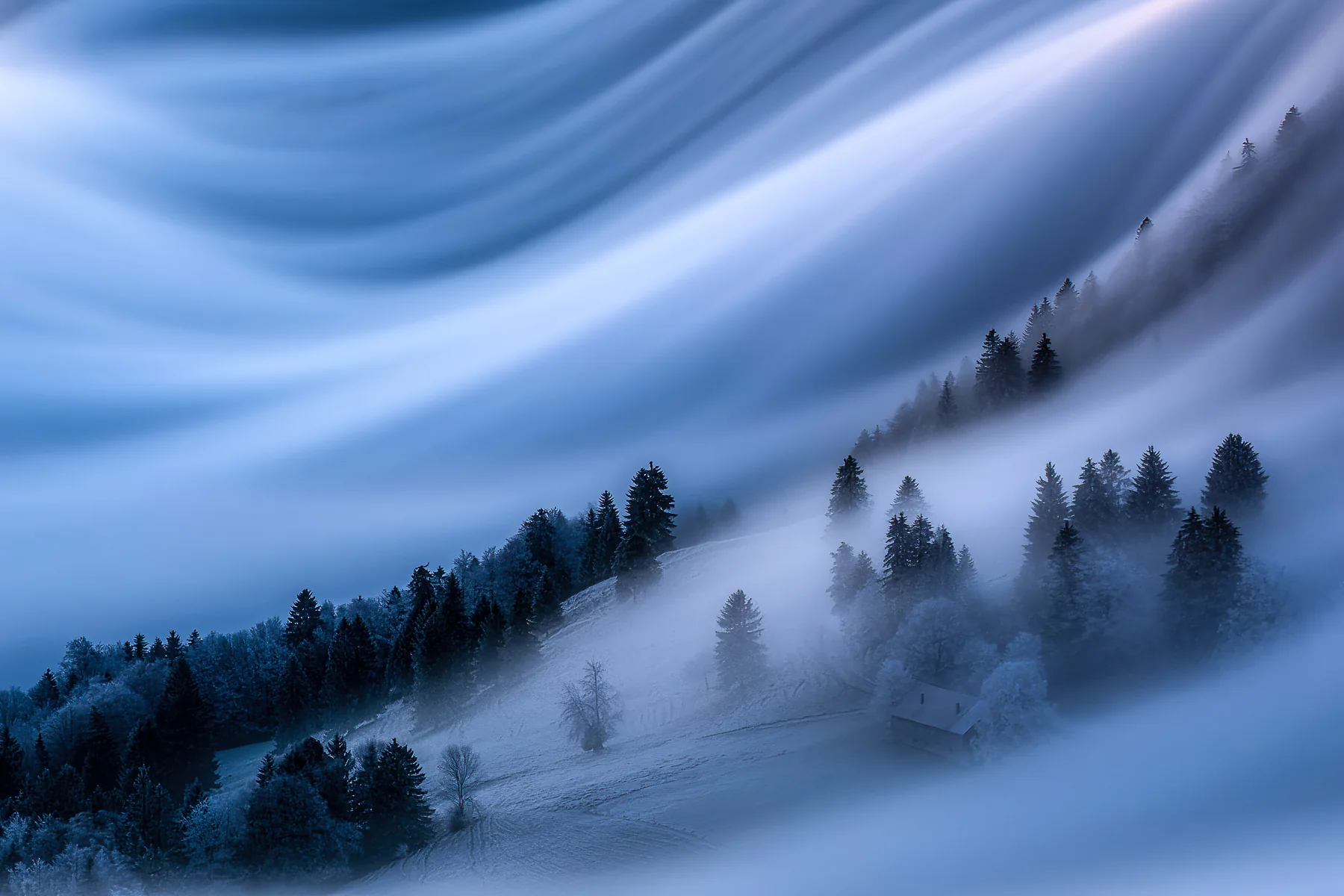 Verschneite Winterlandschaft mit dichtem Nebel über Tannenwäldern am Scheltenpass in Solothurn, dramatische Lichtstrahlen...